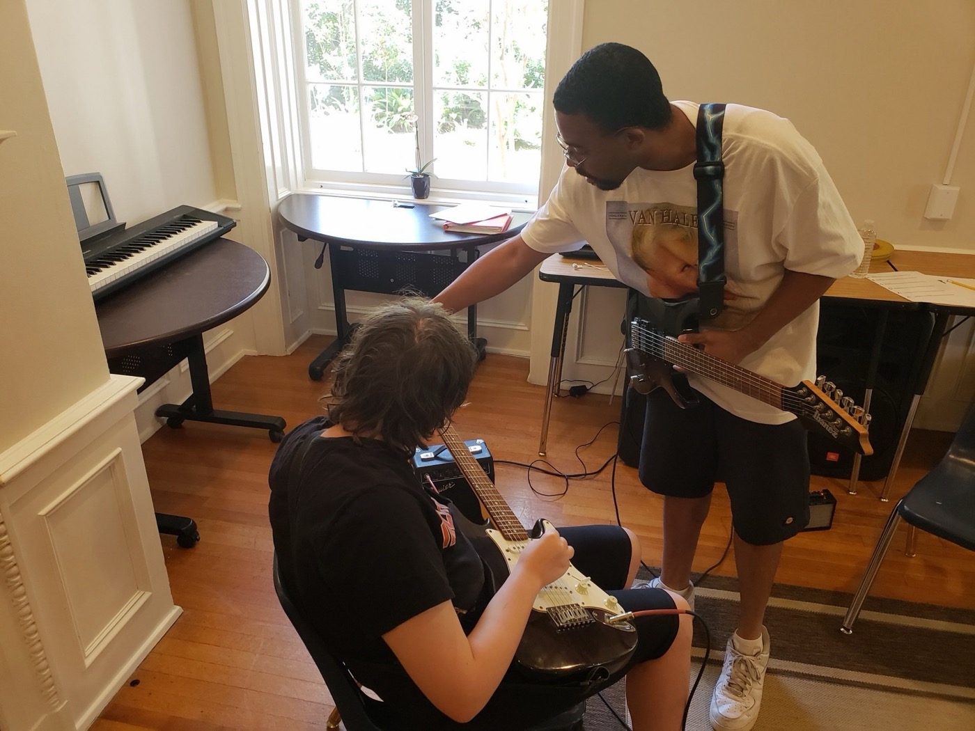 A young Jazz Hands student learns guitar with an instructor