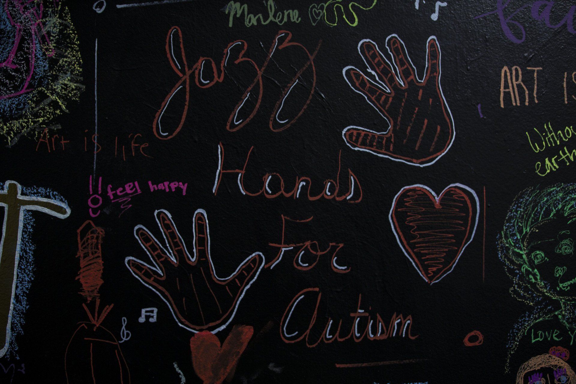 A chalkboard drawing of the Jazz Hands For Autism logo