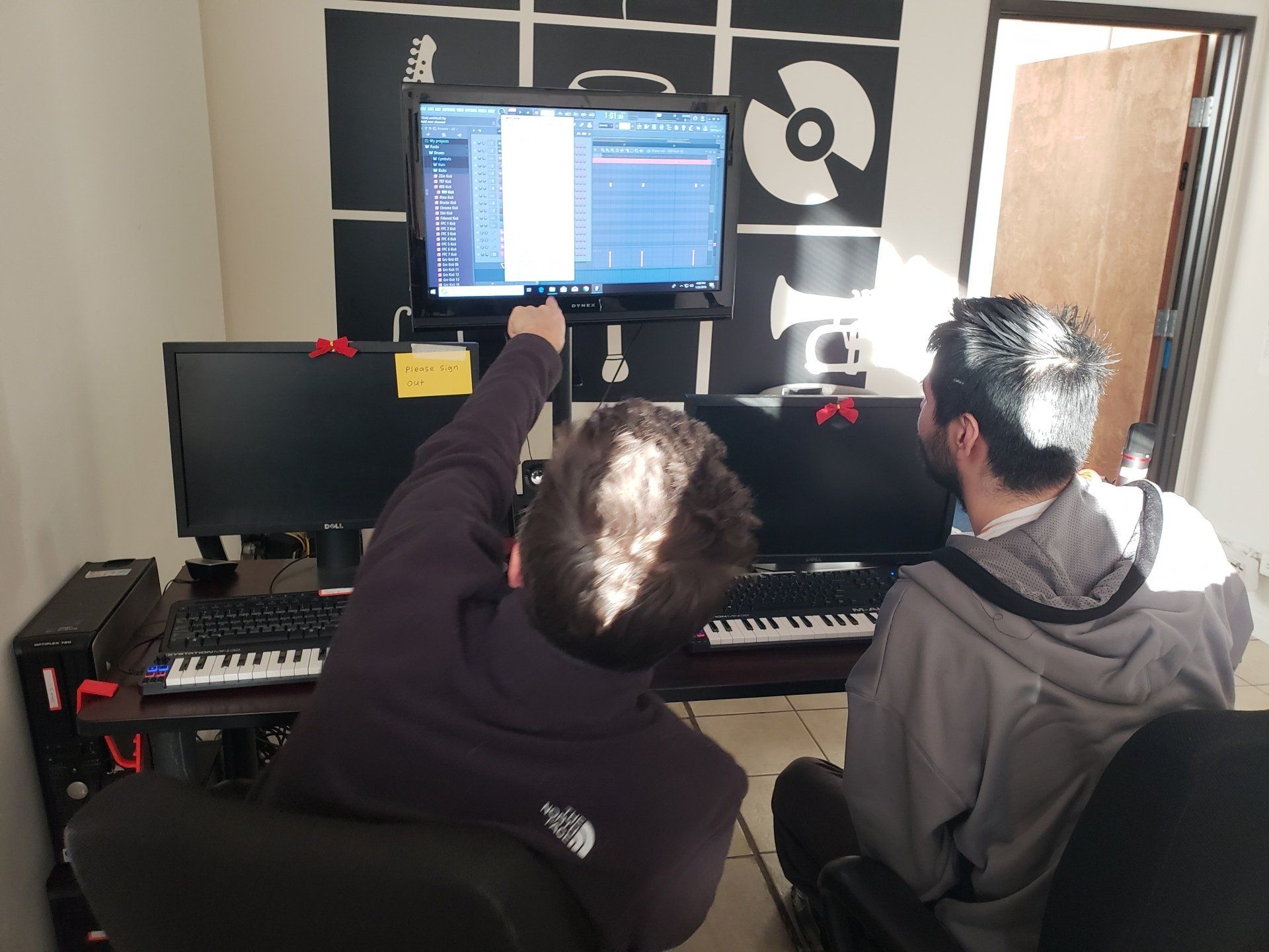 A musician and engineer work at the studio workstation